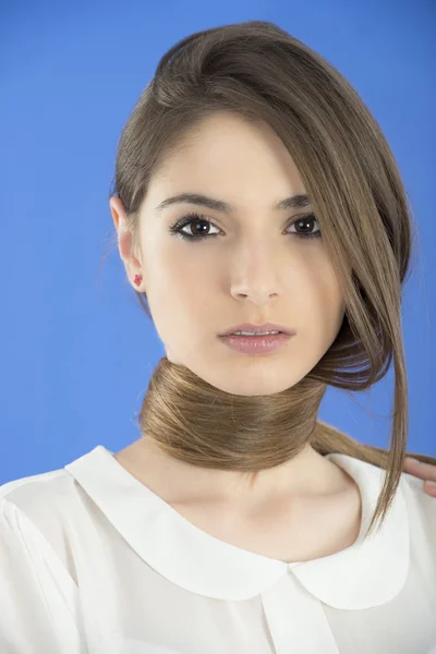 Mujer joven con el pelo largo sobre fondo azul — Foto de Stock