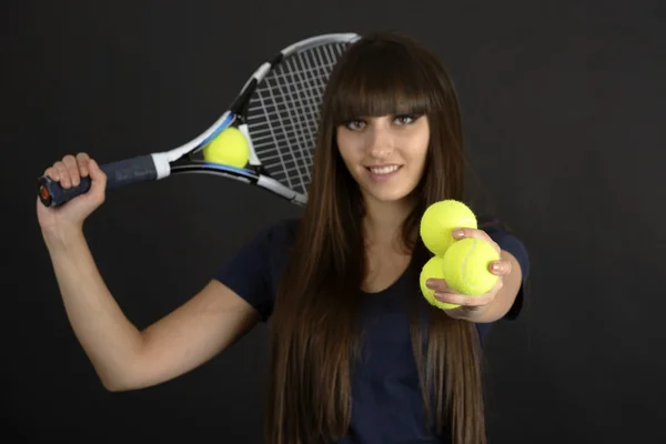 Female tennis player with racket and ball on black background — Stock Photo, Image