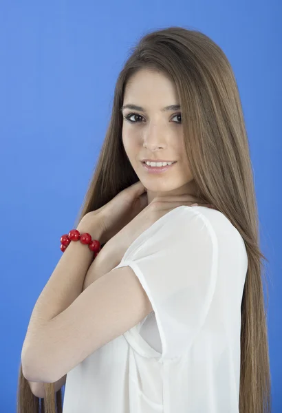 Portrait of a young woman standing against a blue background — Stock Photo, Image