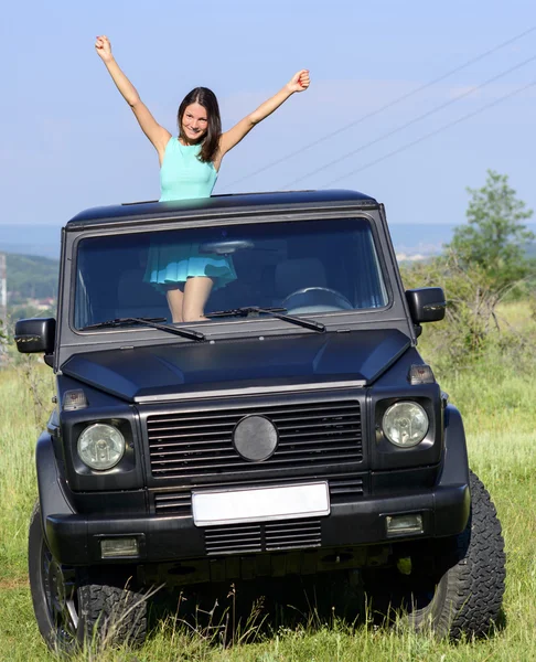 Szczęśliwa młoda kobieta wychodzi Szyberdach w samochodzie — Zdjęcie stockowe