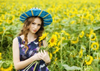 Yaz aylarında çiçek açan üzerinde genç güzel kadın ayçiçeği alan