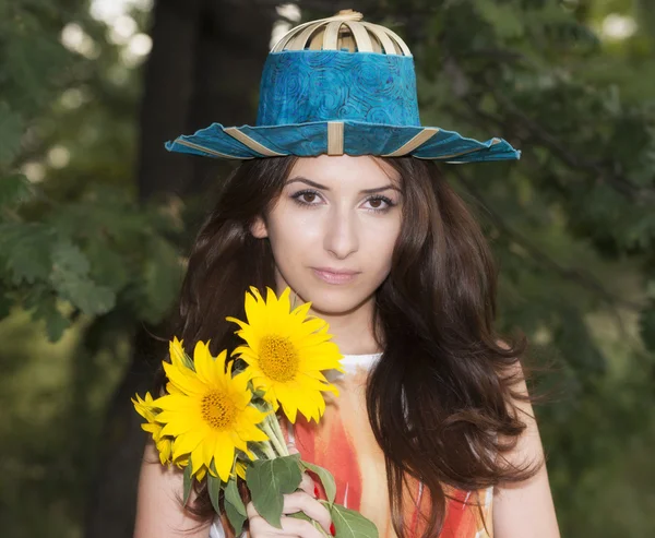 Pole młoda piękna kobieta na kwitnące słonecznika latem — Zdjęcie stockowe