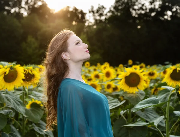 Romantische vrouw met roos liggend op zonnebloemen veld — Stockfoto