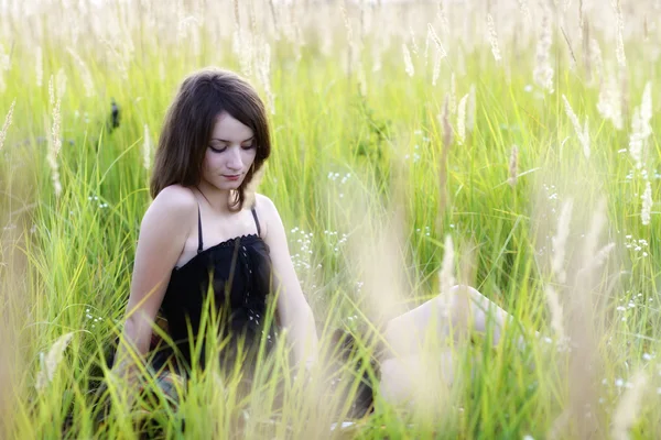 La ragazza seduta su un'erba, che legge un libro — Foto Stock