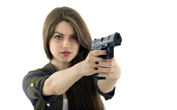 Young beautiful woman holding a gun on white background — Stock Photo, Image