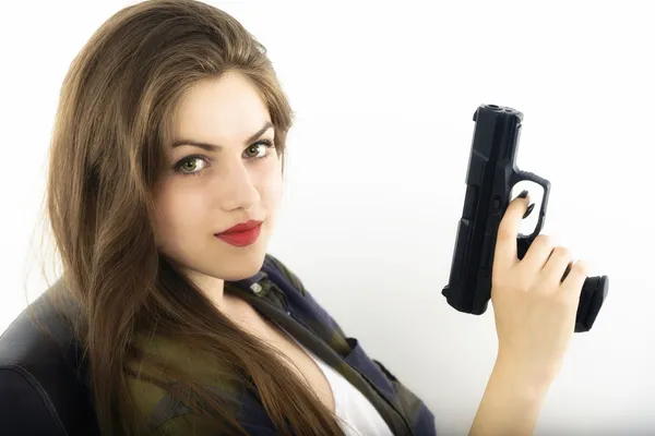 Young beautiful woman holding a gun on white background — Stock Photo, Image