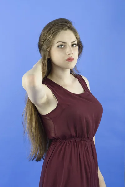 Studio portrait of beautiful woman with long hair on blue backgr — Stock Photo, Image