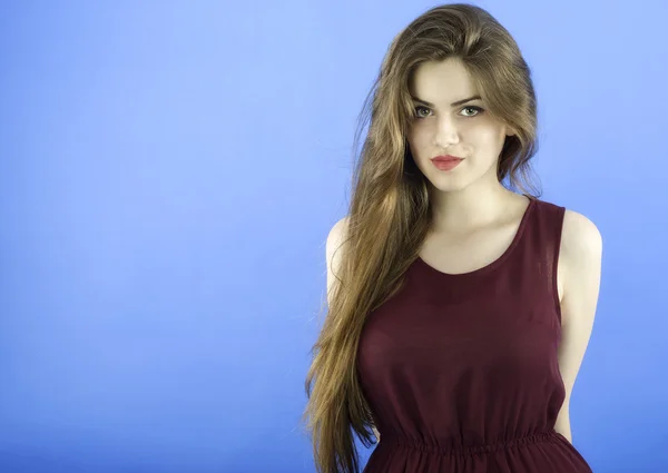 Studio portrait of beautiful woman with long hair on blue backgr — Stock Photo, Image