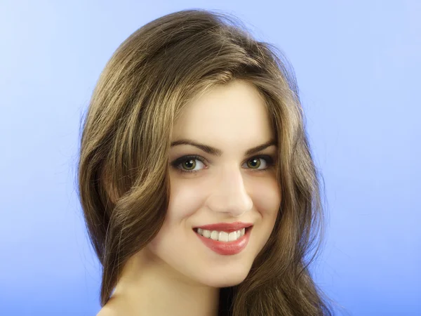 Studio portrait of beautiful woman with long hair on blue backgr — Stock Photo, Image