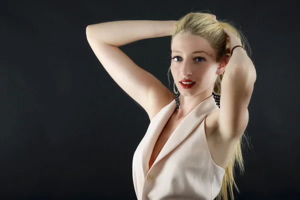 Junge schöne blonde glamouröse Frau in Jacke über dunklem Rücken — Stockfoto