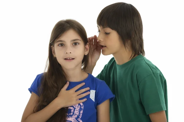 Little boy whispering something to surprised girl, isolated on w — Stock Photo, Image