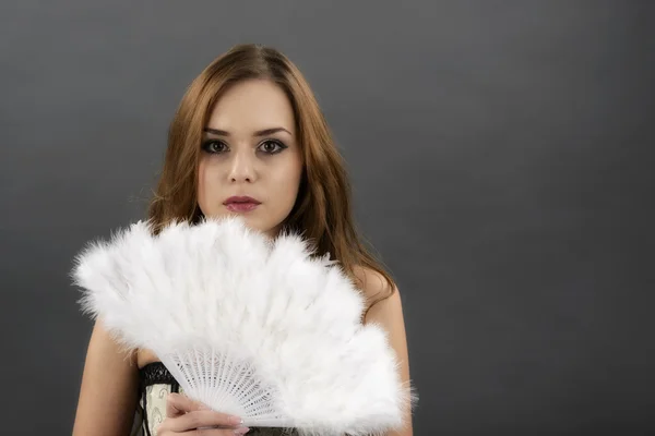 The young woman with a fan from gray feathers — Stok fotoğraf