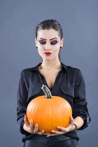 Beautiful girl with pumpkin in the studio isolated on gray backg — Stock Photo, Image