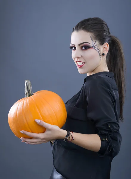 Belle fille avec citrouille dans le studio isolé sur fond gris Image En Vente