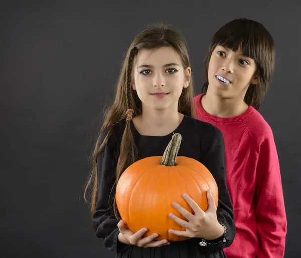 Boy and girl wearing halloween costume with pumpkin on black ba — Stock Photo, Image