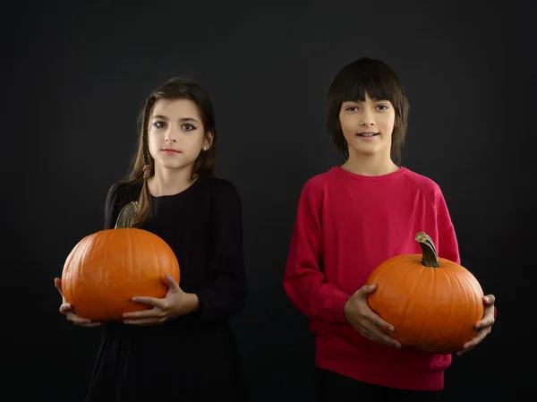Boy and girl wearing halloween costume with pumpkin on black ba — Stock Photo, Image