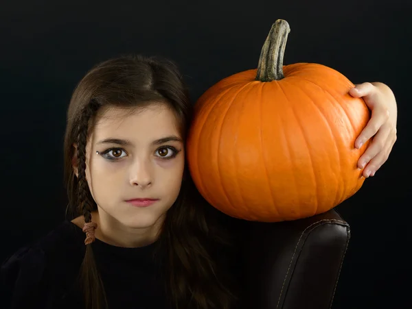 Little witch holding a pumpkin on halloween time — Stock Photo, Image