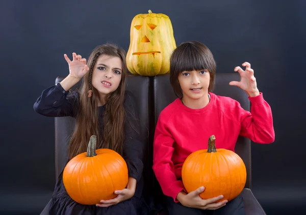 Boy and girl wearing halloween costume with pumpkin on black ba — Stock Photo, Image