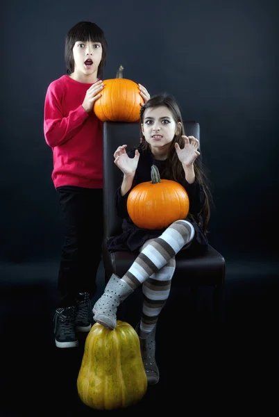 Boy and girl wearing halloween costume with pumpkin on black ba — Stock Photo, Image