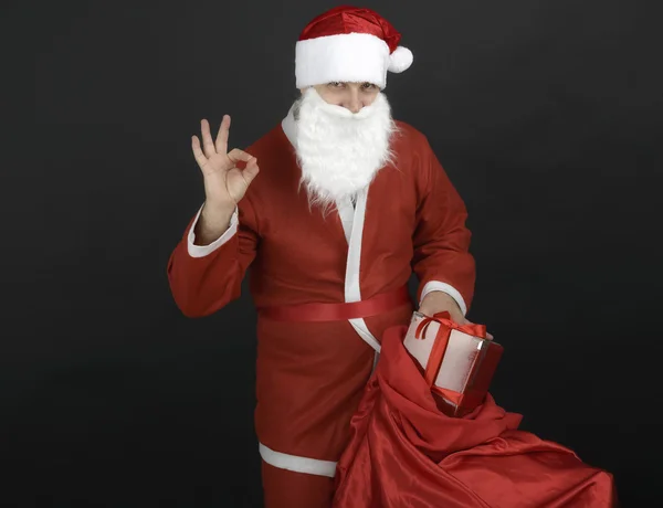 Santa Claus con saco de Navidad y cajas de regalo aisladas en negro — Foto de Stock