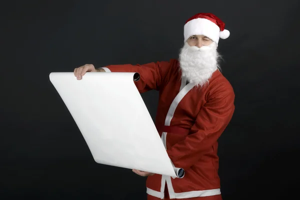 阅读礼物清单，黑色的背景上孤立的圣诞老人 — 图库照片
