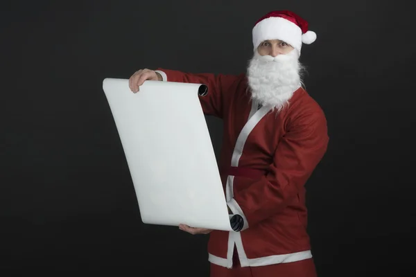 Santa Claus lectura de la lista de regalos, aislado sobre fondo negro — Foto de Stock