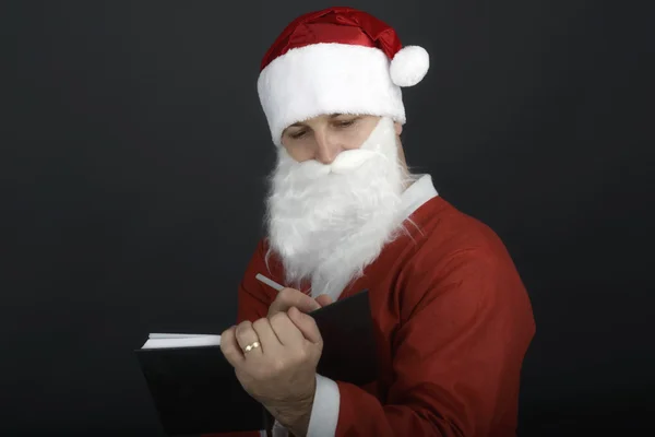 Retrato navideño de Santa Claus escribiendo una lista aislada sobre un — Foto de Stock