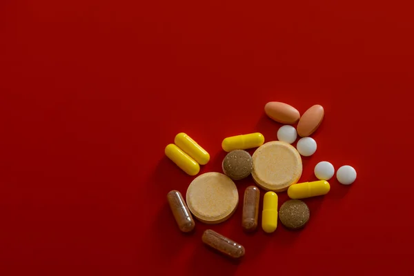 Diferentes drogas isoladas em fundo vermelho — Fotografia de Stock