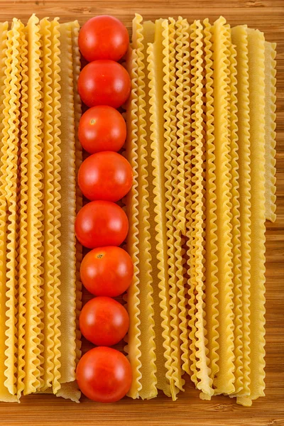 Italiaanse pasta spaghetti en cherry tomaat geïsoleerd op houten bac — Stockfoto