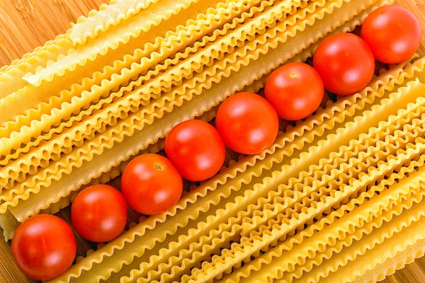 Italiaanse pasta spaghetti en cherry tomaat geïsoleerd op houten bac — Stockfoto