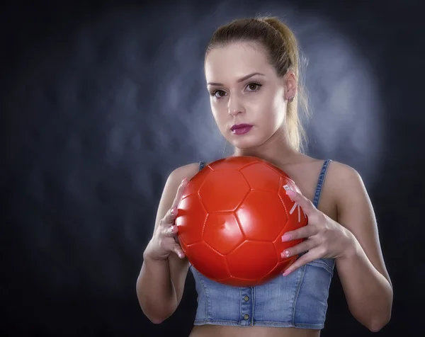 Mulher com bola de futebol isolada no fundo preto — Fotografia de Stock
