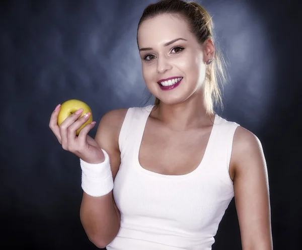 Atletica donna mani mature mela gialla, isolato su nero — Foto Stock