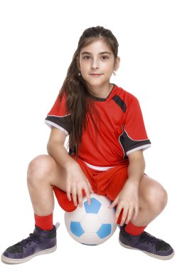 Komple futbol kıyafeti bir futbol üzerinde oturan kız
