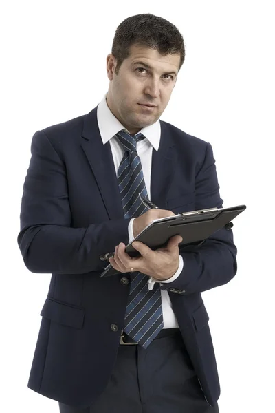 Geschäftsmann schreibt auf Klemmbrett trägt eleganten Anzug und Krawatte isola — Stockfoto