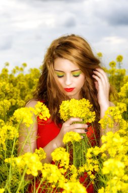 Alandaki sarı kırmızı elbiseli güzel genç kadın