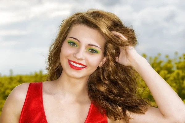黄色のフィールドに赤いドレスで美しい若い女性 — ストック写真