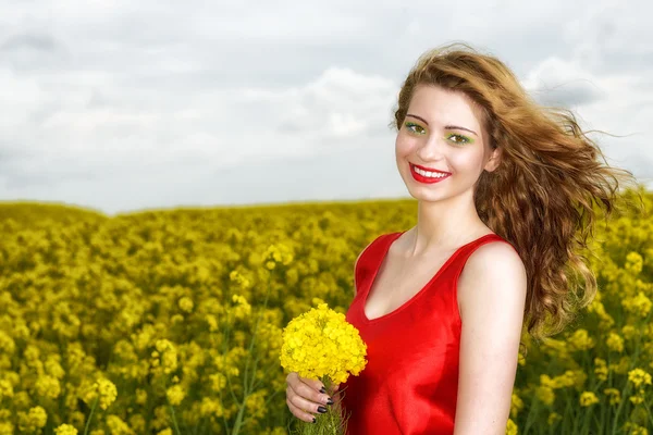 Hermosa joven en vestido rojo en el campo amarillo — Foto de Stock