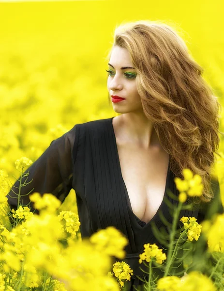 Hermosa joven en vestido negro en el campo amarillo — Foto de Stock