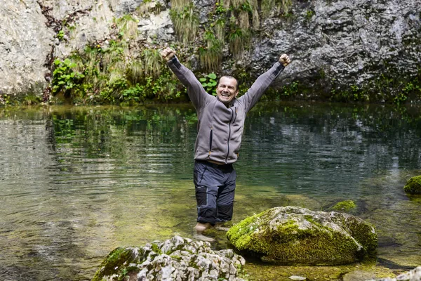Hombre en una montaña río brazos arriba disfrutando — Foto de Stock