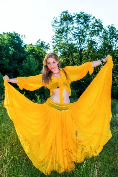 Beautiful woman in yellow dress posing in nature — Stock Photo, Image