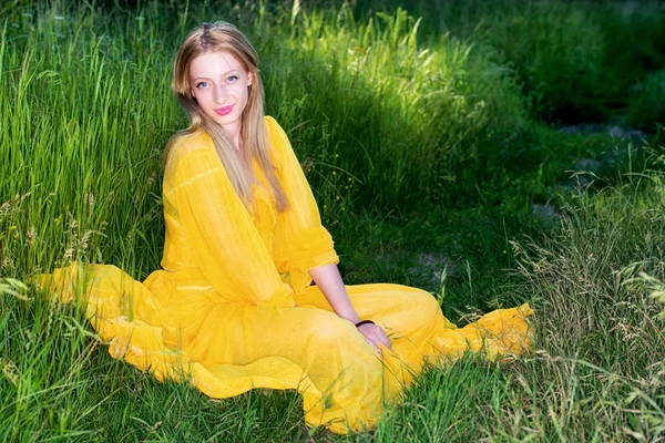 Schöne Frau in gelbem Kleid posiert in der Natur — Stockfoto