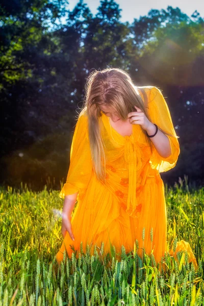 beautiful woman in yellow dress posing in nature