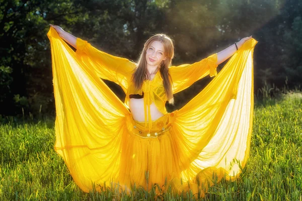 Beautiful woman in yellow dress posing in nature Stock Image