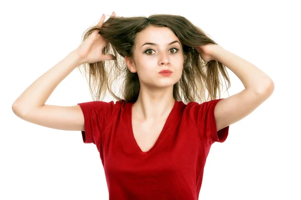 Молодая женщина тянет поврежденные волосы обеими руками — стоковое фото