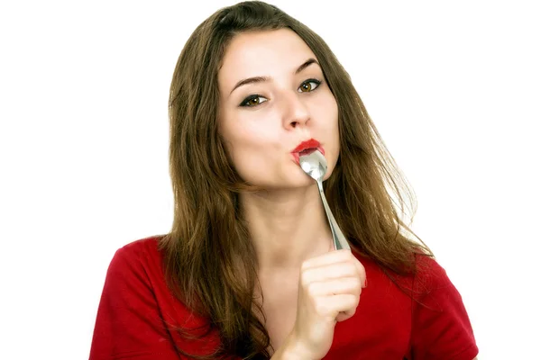 Portrait of young smiling woman with spoon in her mouth and — Stock Photo, Image