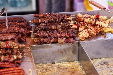 Metal şişte pişen ızgara kebap. Barbeküde pişmiş et. Barbekü taze et dilimleri. Geleneksel doğu yemeği, şiş kebap. Kömür ve alevler üzerine ızgara, piknik, sokak yemekleri