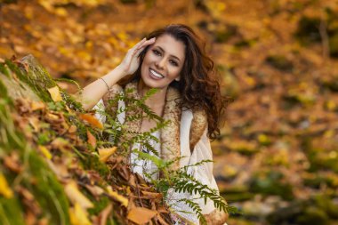 Sonbahar mevsiminde bir dağ nehrinin yanında farklı pozisyonlarda güzel bir kadınla sonbahar portresi..