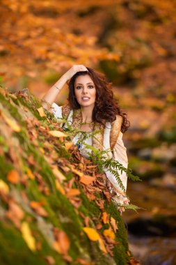 Sonbahar mevsiminde bir dağ nehrinin yanında farklı pozisyonlarda güzel bir kadınla sonbahar portresi..