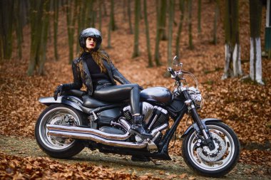 Sonbahar manzarasında helikopter motosikletinde uzun saçlı güzel bir kadın..
