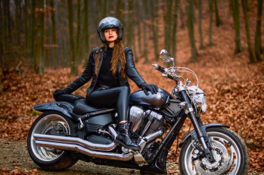 Sonbahar manzarasında helikopter motosikletinde uzun saçlı güzel bir kadın..